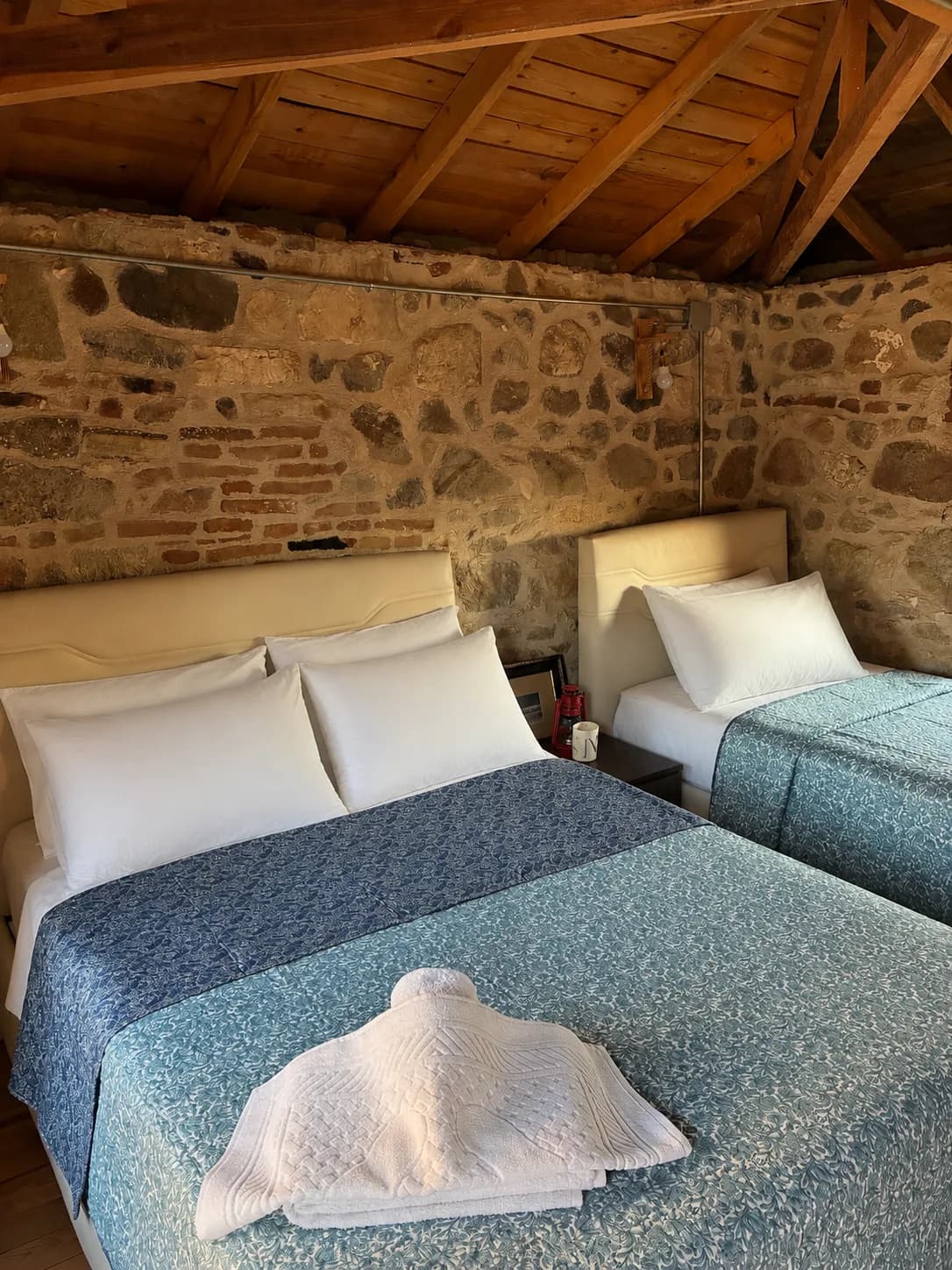 Vesta House Bademli'de taş duvarlı bir oda ve ahşap oyma kapı